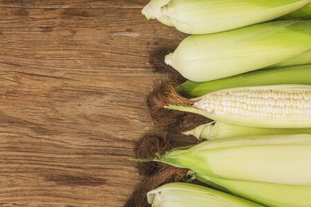 Grains of ripe corn on wooden background.