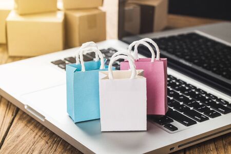 Colorful paper shopping bags in a trolley. Ideas about online shopping addiction.の写真素材