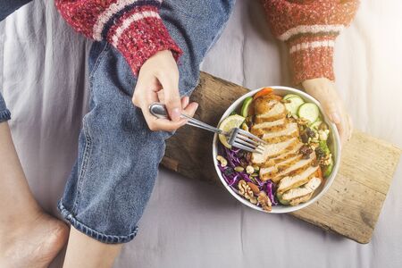 Clean and balanced healthy food conceptï¼Housewife relaxed enjoying chicken breast salad at homeの写真素材