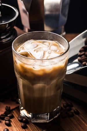 close up view of ice cubes in cold brewed coffee in glass on dark background