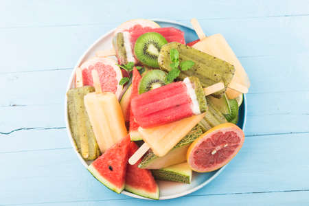 Healthy Whole Fruit ice cream stick with Berries Kiwi watermelon cantaloupe on wooden vintage table