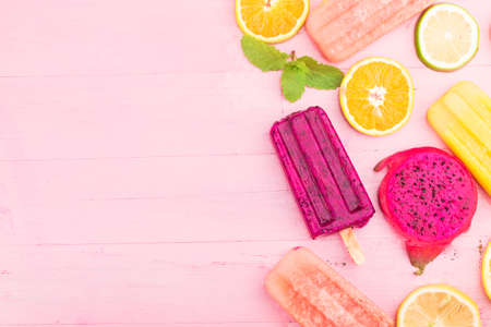 Various fresh fruit popsicles placed on wooden board backgroundの写真素材