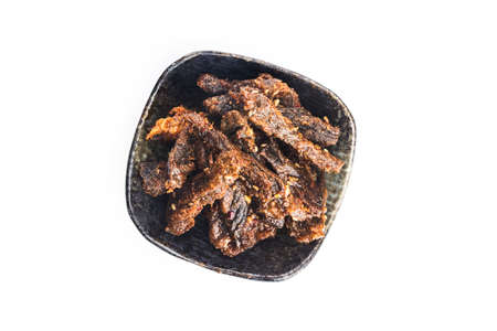 Beef jerky in a bowl on white background