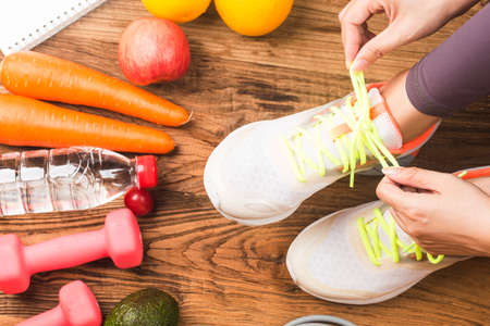 Sport and healthy woman tying her shoes, Workout at home,の写真素材