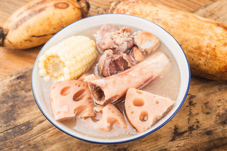 A bowl of pork bone lotus root soup on a wooden tableの写真素材
