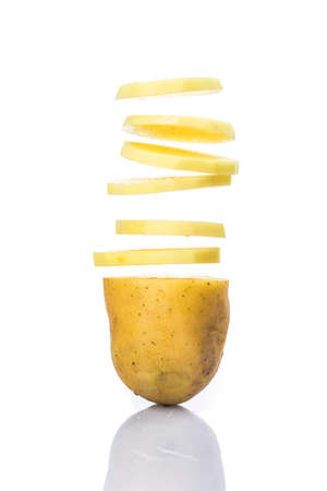 Potato slices turning into chips isolated on white backgroundの写真素材