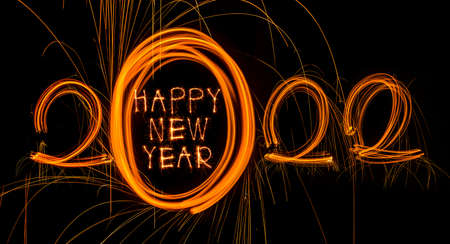 Happy New Year 2022. Sparkling burning text Happy New Year 2022 isolated on black background. Beautiful Glowing golden overlay object for design holiday greeting cardの写真素材