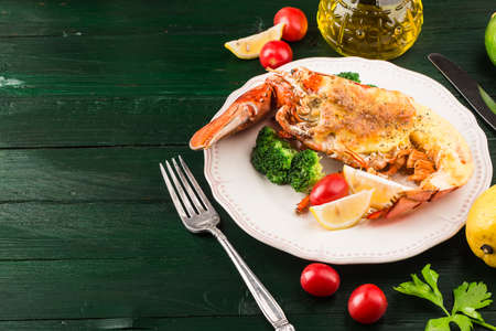 Lobster Thermidor, grilled lobster stuffed with cream and cheese, served with lemon, Boston lobster...
