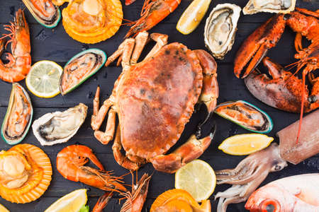 Seafood dinner, seafood dinner with fresh lobster, crab, mussel and oyster as backgroundの写真素材