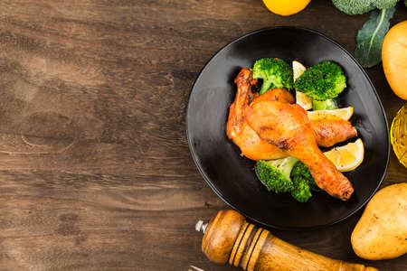 Grilled chicken leg with boiled potatoes and vegetableの写真素材