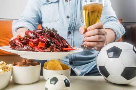 Eating snacks and beer and watching football liveの写真素材