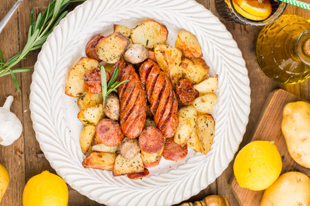 A plate of delicious potatoes and baked sausageの写真素材