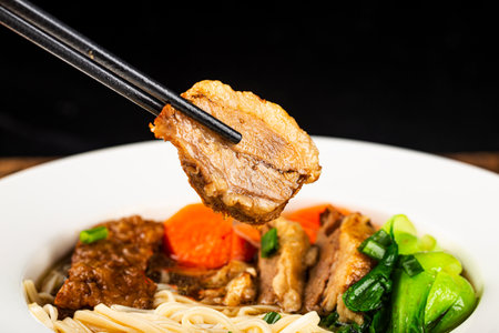 Spicy soup red beef noodle in a bowl on wooden tableの写真素材