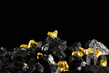 Coal on a black background. Gold and black coal on black background.