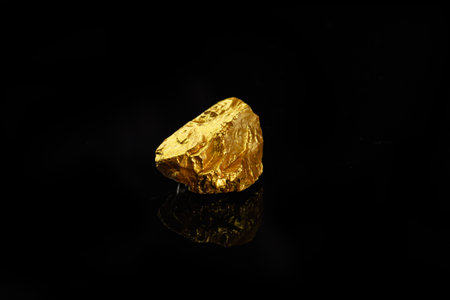 Gold nugget on black background, precious stone or lump of gold
