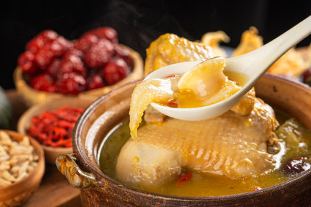Chicken soup in a clay pot on a wooden table. Chinese cuisine.の写真素材