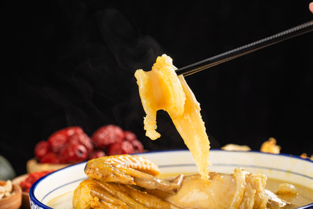 chinese cuisine. close up of chopsticks dipping in chinese soupの写真素材
