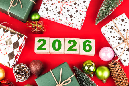 Happy New Year 2026 with Christmas gifts and ornaments on red background
