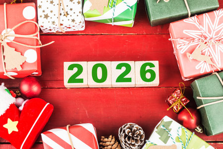 Happy New Year 2026 with Christmas gifts and ornaments on red background
