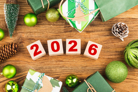 Wooden cubes with numbers 2026 and Christmas decorations on a wooden background
