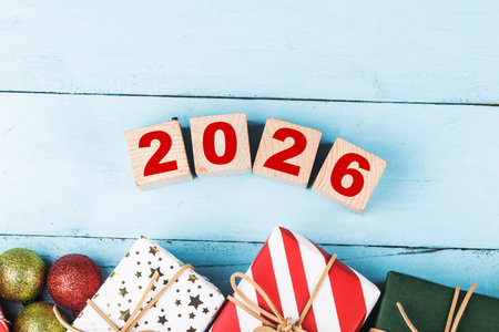Top view of wooden block with number 2026 and christmas decoration on blue wooden background