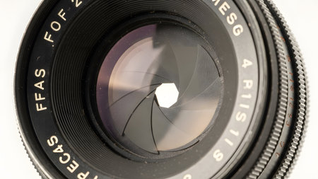 Isolated showing extreme close-up of a camera lens aperture with hexagonal opening and textured...