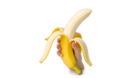 Showing hand peeling a ripe yellow banana showing the white flesh on white background....の写真素材