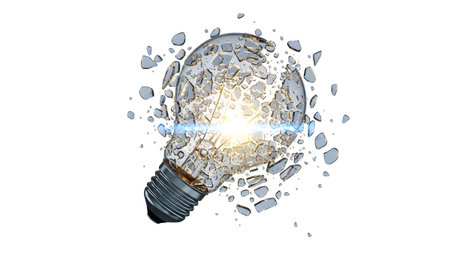 A clear glass light bulb is shattering with a bright yellow filament glowing and blue light...