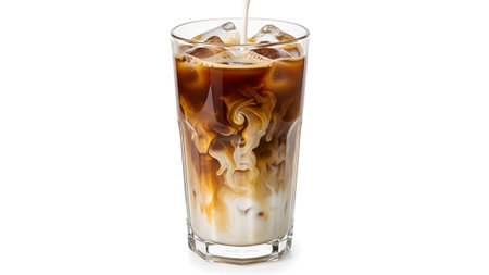 showing pouring milk into a glass of iced coffee with ice and cream swirls.