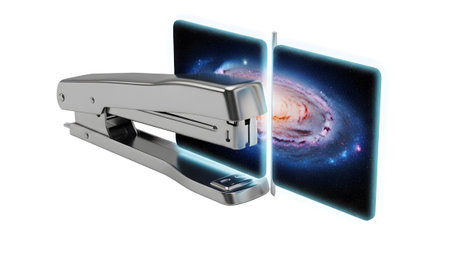 A silver stapler is positioned to pierce a glowing digital screen that a detailed spiral galaxy.