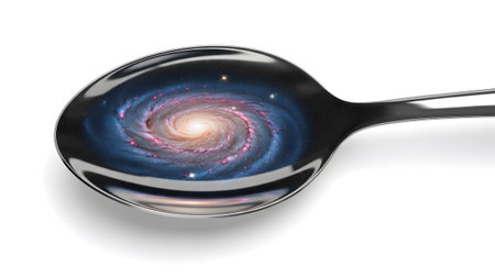 showing spiral galaxy reflected in a shiny metal spoon on white background.