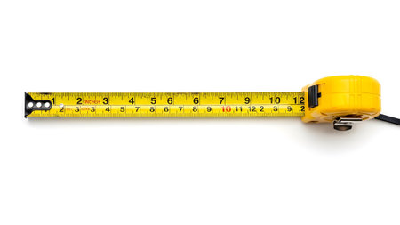 White showing yellow tape measure extended showing inches and centimeters on a white background....