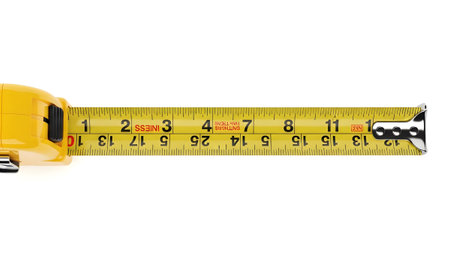 White showing yellow tape measure with extended metal end showing inches and centimeters on...