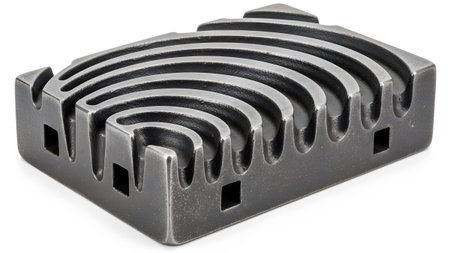 Background showing dark grey metal block with curved grooves and square cutouts on a white...