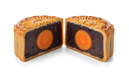 showing halved mooncake with golden crust and dark filling revealing a bright orange...
