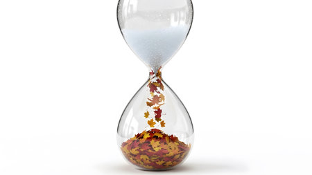 showing hourglass with falling autumn leaves and white sand against a white background....