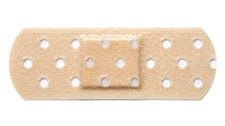 showing a standard beige adhesive bandage with a white perforated backing and a light tan...