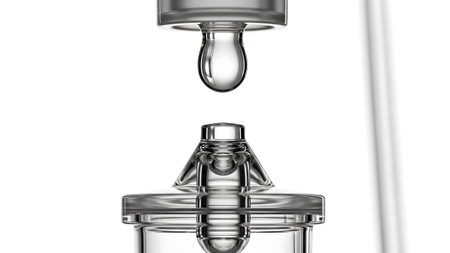Dropper showing clear liquid droplet falling from clear glass dropper into clear glass container...
