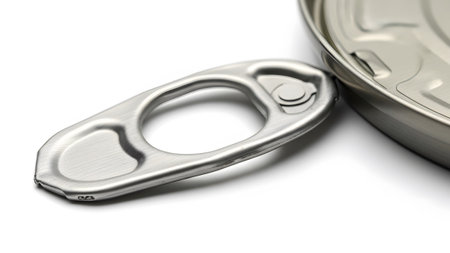 Surface showing metallic ring pull tab from a can lying on a white surface next to the can rim...