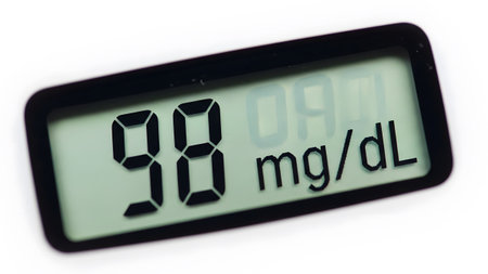 showing digital glucose meter displaying a reading of 98 mg/dl on white background.