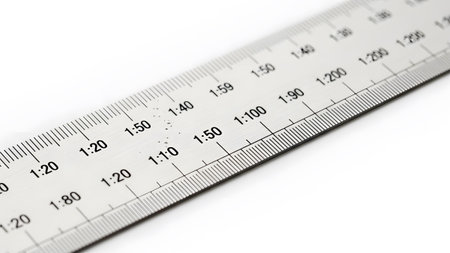Black showing silver metal ruler with black markings showing scale ratios and millimeters on a...