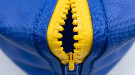 Yellow showing close-up of a partially open blue bag with a bright yellow zipper.