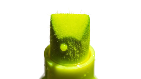 Spray showing macro view of a bright green spray bottle nozzle with visible hairs and droplet....