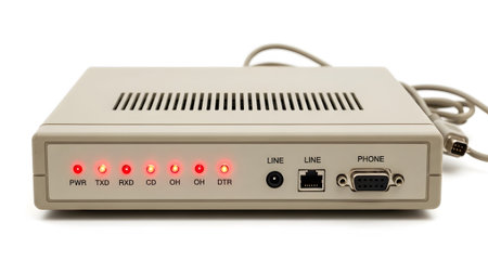 Vintage showing vintage beige modem with illuminated red status lights and various ports on...