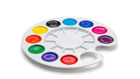 A white plastic palette with twelve circular wells filled with vibrant liquid paints and a...