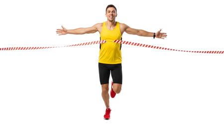 A man in a yellow tank and black shorts joyfully crosses a red and white striped finish line...