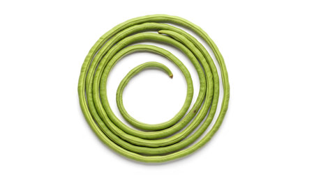 A top-down view of coiled green long beans forming a spiral shape against a clean white background.