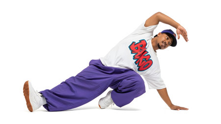 Breakdancer showing breakdancer in purple pants performing a ground move on white.