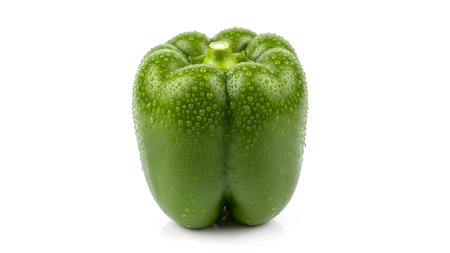 A vibrant green bell pepper glistening with numerous small water droplets against a clean white...の写真素材