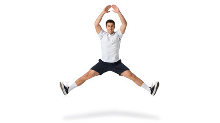 Shorts showing athletic man in white polo and dark shorts performing a jumping jack exercise on...